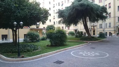 a street in front of a large building with a tree at Double room da Giulio in Rome