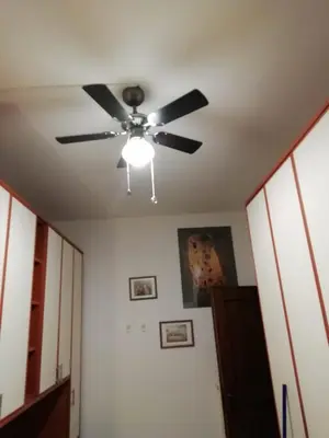 a ceiling fan in a room with a hallway at Double room da Giulio in Rome