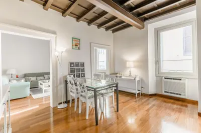 a dining room with a glass table and white chairs at Navona Bernini Lodge in Rome