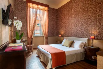 a hotel room with a bed and a desk and a television at Welcome House in Rome