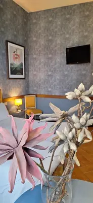 a vase with flowers on a table in a room at Welcome House in Rome