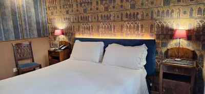 a bedroom with a large bed with a blue headboard at Welcome House in Rome