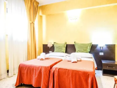 a hotel room with two beds with red sheets at B&B Morelli 1 in Rome