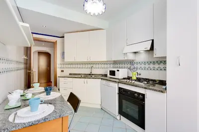 a kitchen with white cabinets and a counter top at Rome as you feel - Panisperna Apartment in Rome