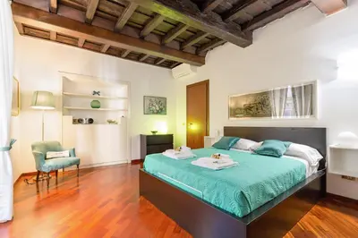 a bedroom with a large bed and a chair at Rome as you feel - Panisperna Apartment in Rome