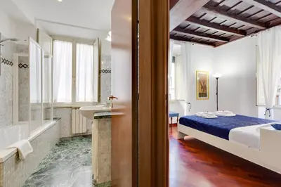 a bedroom with a bed and a tub and a sink at Rome as you feel - Panisperna Apartment in Rome