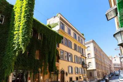 a building with ivy growing on it on a street at Rome as you feel - Panisperna Apartment in Rome