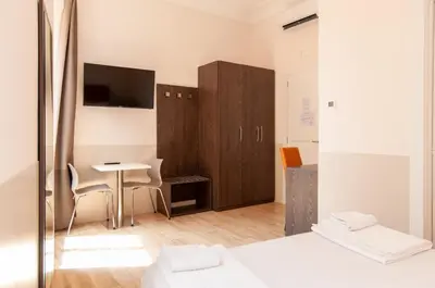 a bedroom with a desk and a table with a chair at Domus Porta Angelica in Rome