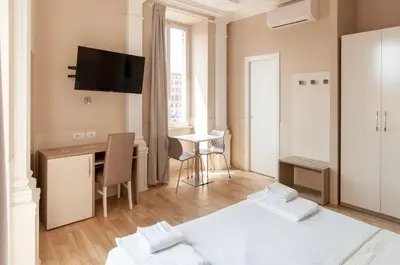 a room with a desk and a table with a bed at Domus Porta Angelica in Rome