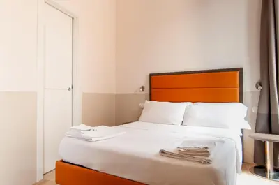 a bedroom with a large bed with a wooden headboard at Domus Porta Angelica in Rome
