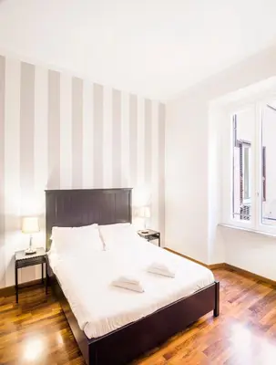 a bedroom with a large bed and two windows at Piazza Cavour Suite in Rome