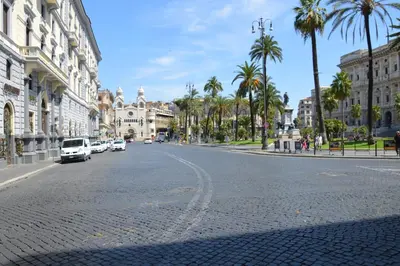 an empty city street with palm trees and buildings at Piazza Cavour Suite in Rome