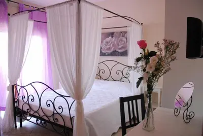 a bedroom with a canopy bed with a vase of flowers at Stefy's Rooms in Rome