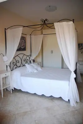 a bedroom with a white bed with curtains at Stefy's Rooms in Rome