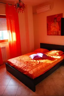 a bedroom with a bed with a red comforter at Stefy's Rooms in Rome