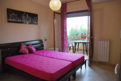 a bedroom with a large bed with a pink cover at Stefy's Rooms in Rome