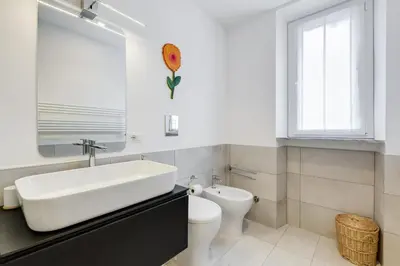 a bathroom with a sink and a toilet and a window at Piazza Navona-Coronari House in Rome