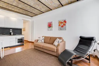 a living room with a couch and a kitchen at Piazza Navona-Coronari House in Rome