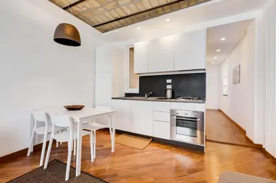 a white kitchen with a white table and chairs at Piazza Navona-Coronari House in Rome