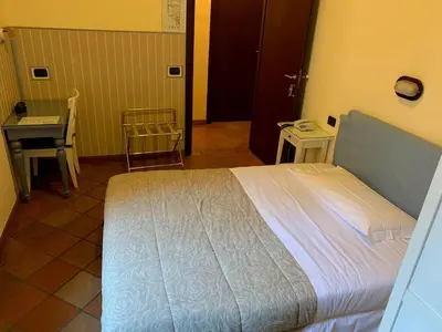 a bedroom with a bed and a table and a desk at Hotel Croce Di Malta in Rome