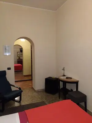 a room with a bed and a chair and a table at Hotel Croce Di Malta in Rome
