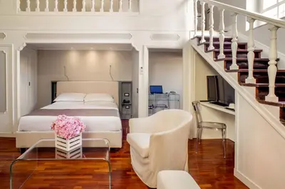 a bedroom with a bed and a table with flowers on it at Les Fleurs Luxury House in Rome