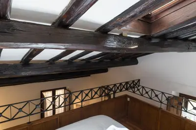 a bedroom with wooden ceilings and a bed with white sheets at Behind Navona in Rome
