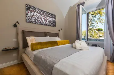 a bedroom with a large bed and a large window at Palazzo Baj in Trastevere in Rome