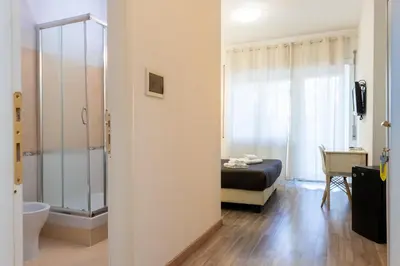a bedroom with a bed and a bathroom with a shower at Aurelia Home Guest House in Rome