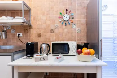 a kitchen counter with a microwave and a bowl of fruit at Aurelia Home Guest House in Rome
