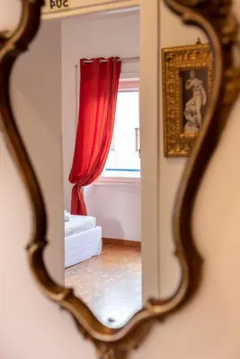 a mirror reflection of a living room with a red curtain at Aurelia Home Guest House in Rome