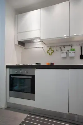 a kitchen with white cabinets and a stove at Secret Rhome Loft in Rome