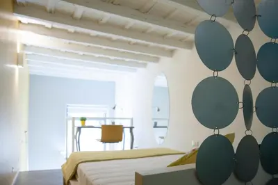 a bedroom with two beds and a wall with circles at Secret Rhome Loft in Rome