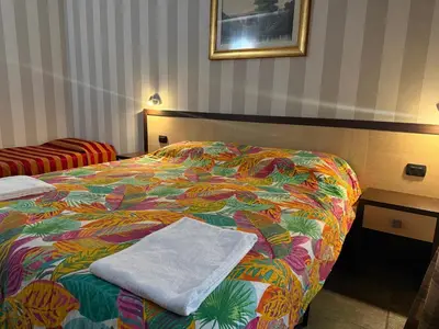 a hotel room with two beds and a window at Clarian Affittacamere in Rome