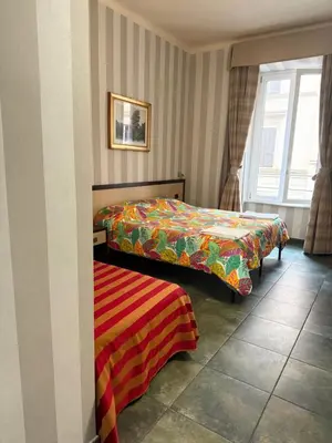 a hotel room with two beds and a picture on the wall at Clarian Affittacamere in Rome