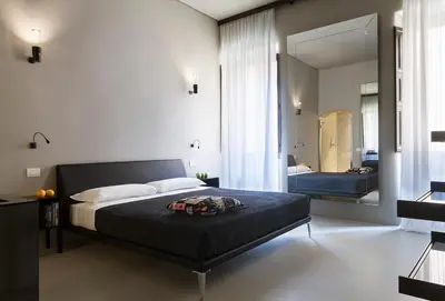 a bedroom with a bed and a large mirror at Casa de' Coronari Suites in Rome