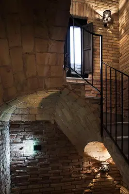 a staircase in an old brick building with a window at Casa de' Coronari Suites in Rome