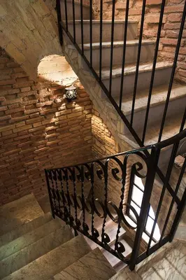 a staircase with a metal railing and a brick wall at Casa de' Coronari Suites in Rome