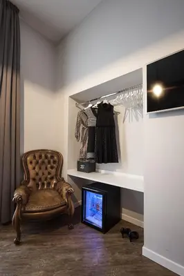 a room with a chair and a tv and a shelf at Ara Suite in Rome