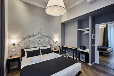 a bedroom with a large bed and a desk at Ara Suite in Rome