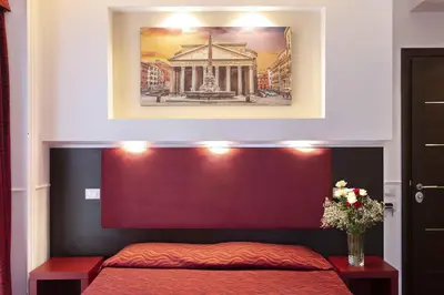 a bedroom with a red bed with a picture above it at Imperial Suite Guest House in Rome