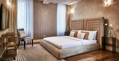 a bedroom with a large bed and a chair at LE RÊVE DE NAIM Roma in Rome
