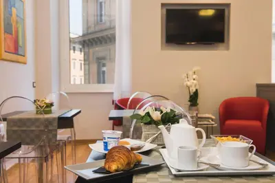 a table with two plates of food and coffee cups at Mascherino Suites in Rome