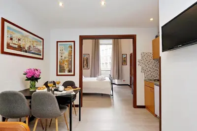 a kitchen and a living room with a table and chairs at 4BNB - Cavour Square Apartment in Rome