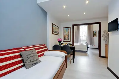 a living room with a bed and a dining room at 4BNB - Cavour Square Apartment in Rome