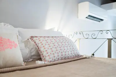 a bed with white pillows and a pillow on it at Frankie Charme in Rome