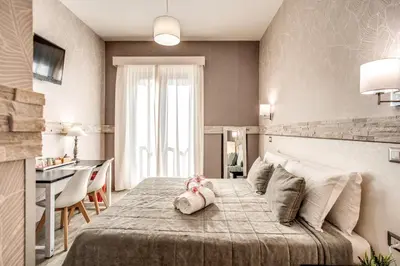 a bedroom with a bed with a pink stuffed animal on it at Santamaria Inn in Rome