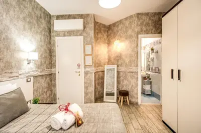 a bedroom with a bed and a dressing room at Santamaria Inn in Rome