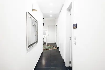 a hallway with white walls and a black tile floor at Ma Belle Maison in Rome