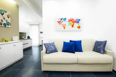 a living room with a white couch and blue pillows at Ma Belle Maison in Rome